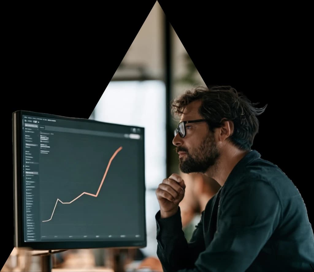 A man studying a performance chart on a large monitor.