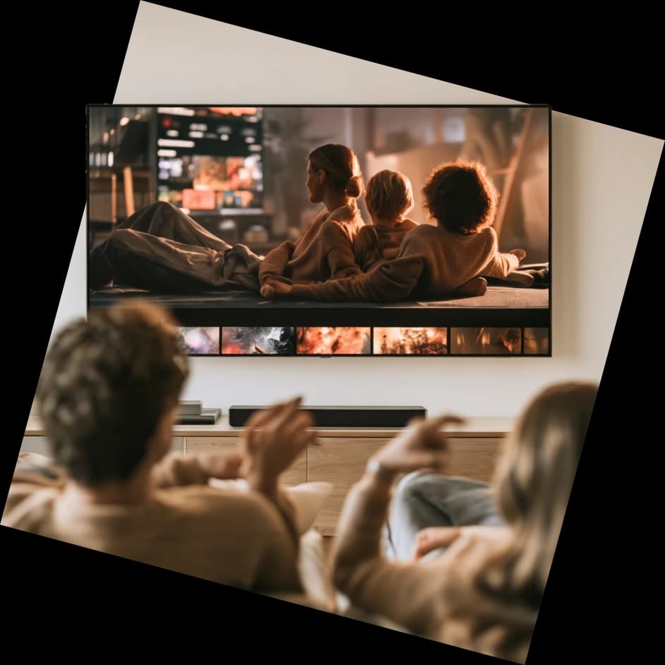 A couple watching a film on a wall-mounted television at home.